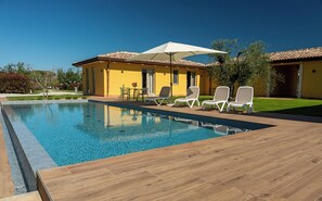 Una piscina al aire libre de temporada, sombrillas