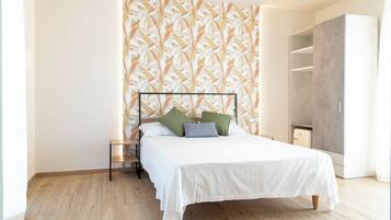 Une chambre à coucher avec un lit, une armoire et un papier peint à motifs.