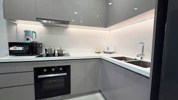 Apartamento superior, vistas al jardín | Cocina privada | Microondas, placa de cocina y utensilios de cocina