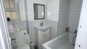 Ein kleines Badezimmer mit Toilette, Waschbecken und Badewanne.
