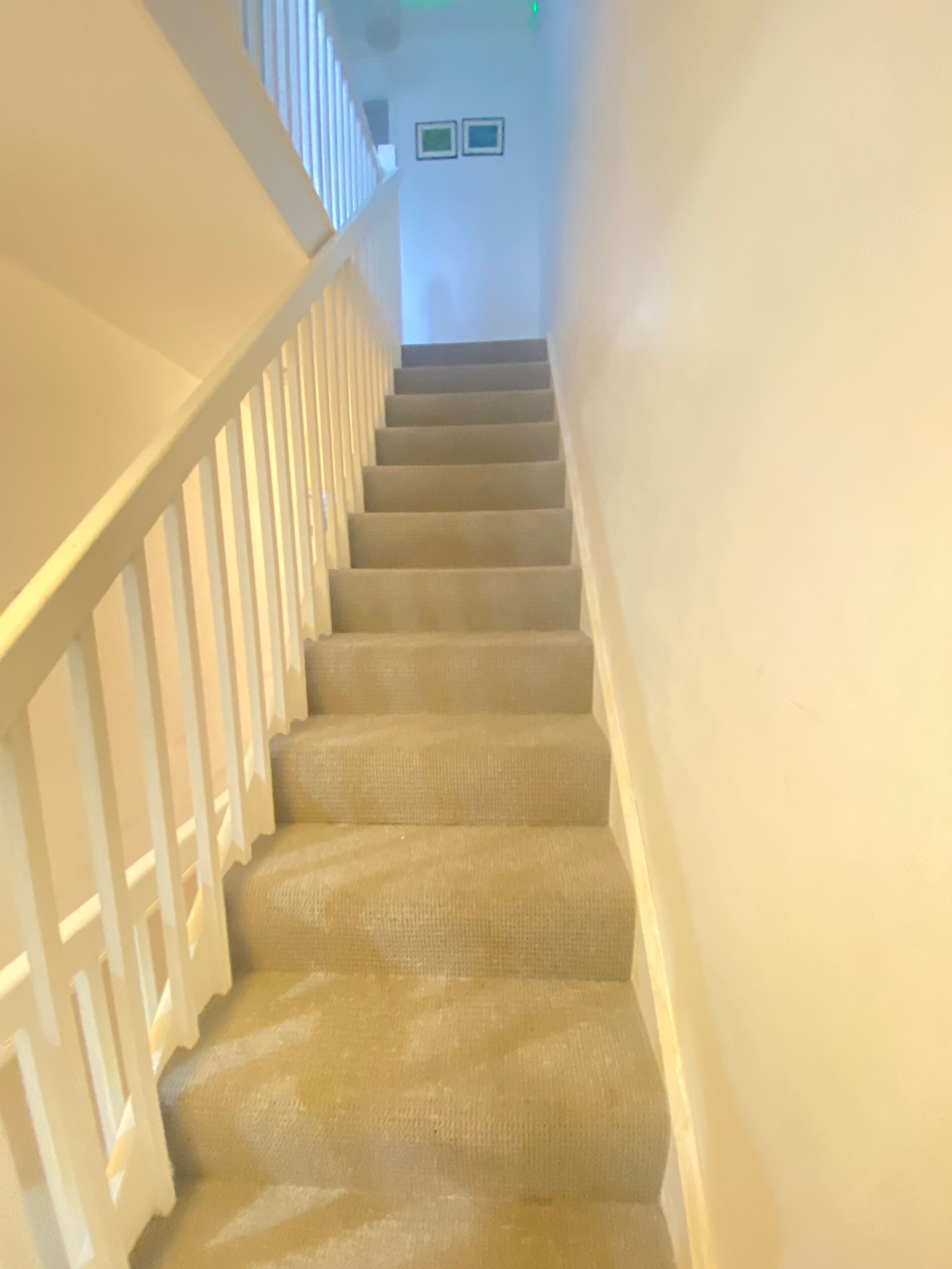 Eine Treppe mit weißen Geländern und beige gefärbten Stufen.