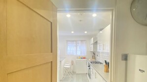 A kitchen with a washing machine, a sink, and a refrigerator. - Luxurious 5 Bedroom Home in Prime London Location (London)
