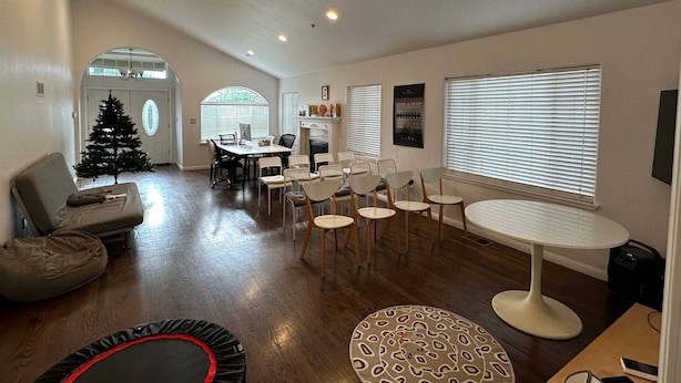 A spacious living room with a fireplace, a dining area, and a Christmas tree.