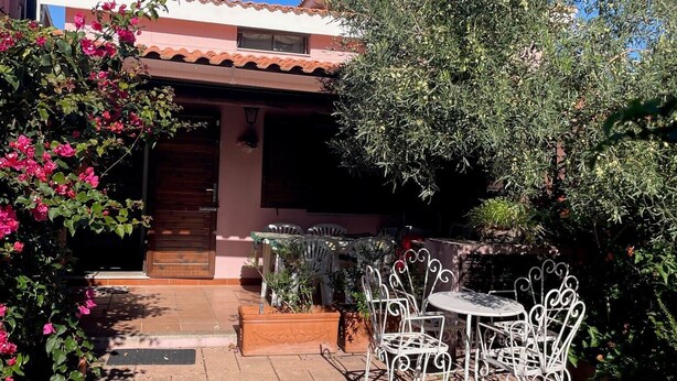 Une terrasse avec des meubles d’extérieur, une porte et un jardin.