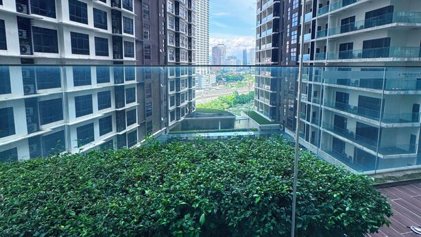 A modern high-rise building with a glass atrium and a rooftop garden. - MERCU SUMMER SUITES MINUTES TO KLCC BY JK PRIVY HOMES (Kuala Lumpur)