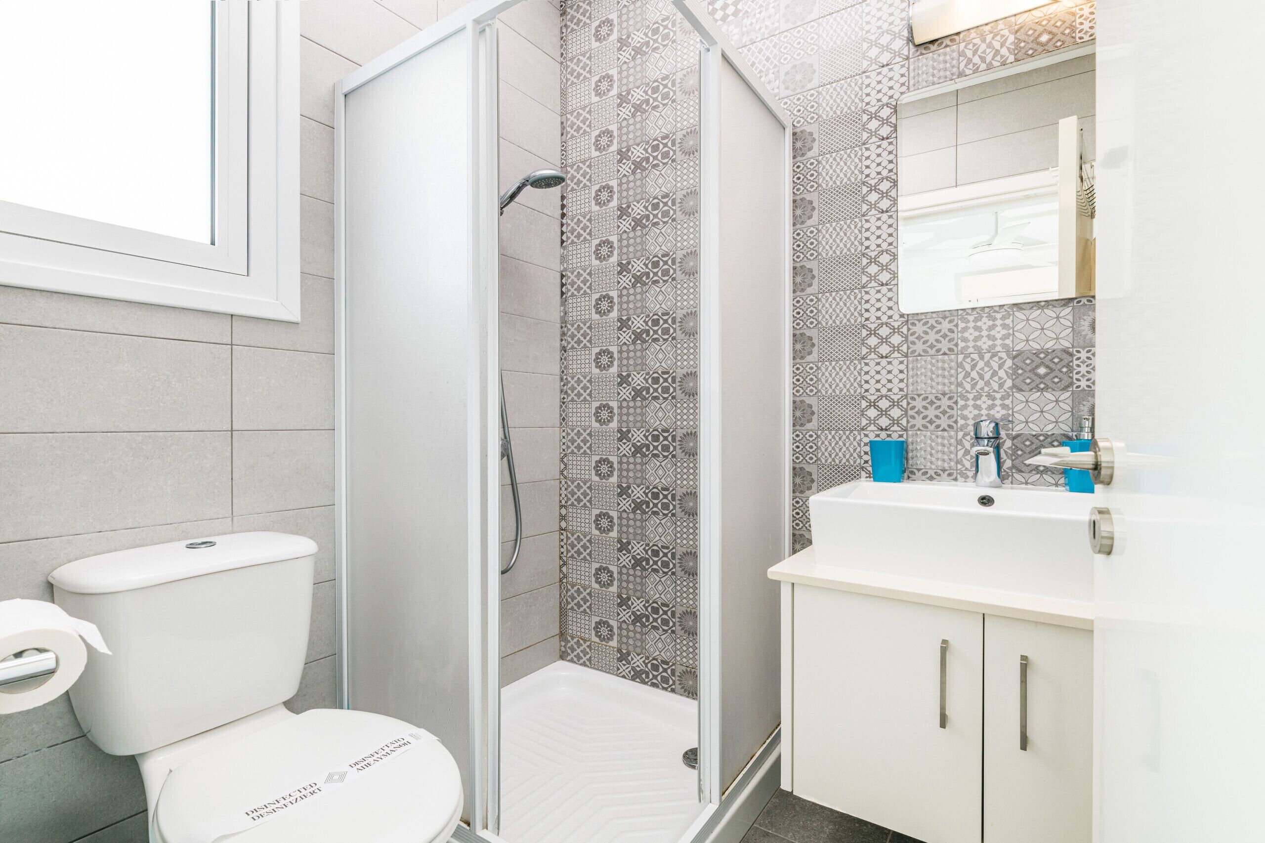 Une salle de bain moderne équipée d’une douche, de toilettes et d’un lavabo.