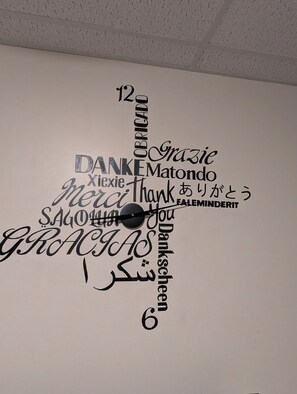 A wall with a clock and various words in different languages expressing gratitude. - "ARTspazio - 470" 2bed 1st Floor  W/D near UPMC (Williamsport)