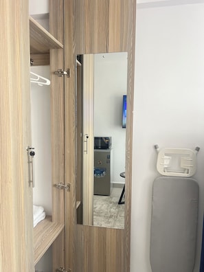 A wooden wardrobe with a mirror, a microwave, and a small table with a chair. - Haza cozy homes Entire rental unit in Nairobi, Kenya (Nairobi)