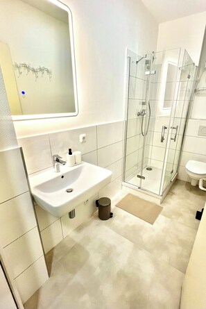 A modern bathroom with a glass-enclosed shower, a white sink, and a toilet. - BIG New 6Rms Boutique Flat City Center, KaDeWe, ZOO, Messe, 1A Location (Berlin)