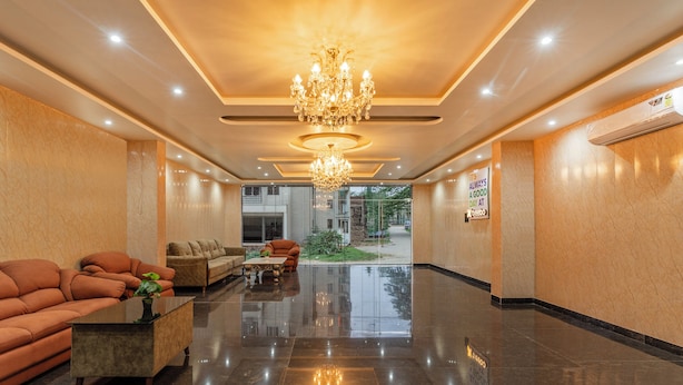 A lobby with a chandelier, sofas, a coffee table, and a view of the outside. - Treebo Sloka Residency (Ranchi)