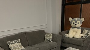 Un salon avec un canapé gris, un fauteuil assorti et une table basse en marbre.