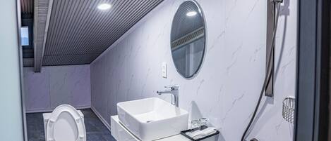 Een moderne badkamer met een wit wastafelmeubel, spiegel en douche.