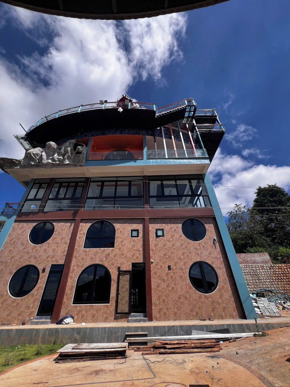 A multi-story building with a modern architectural design, featuring large windows and a balcony.