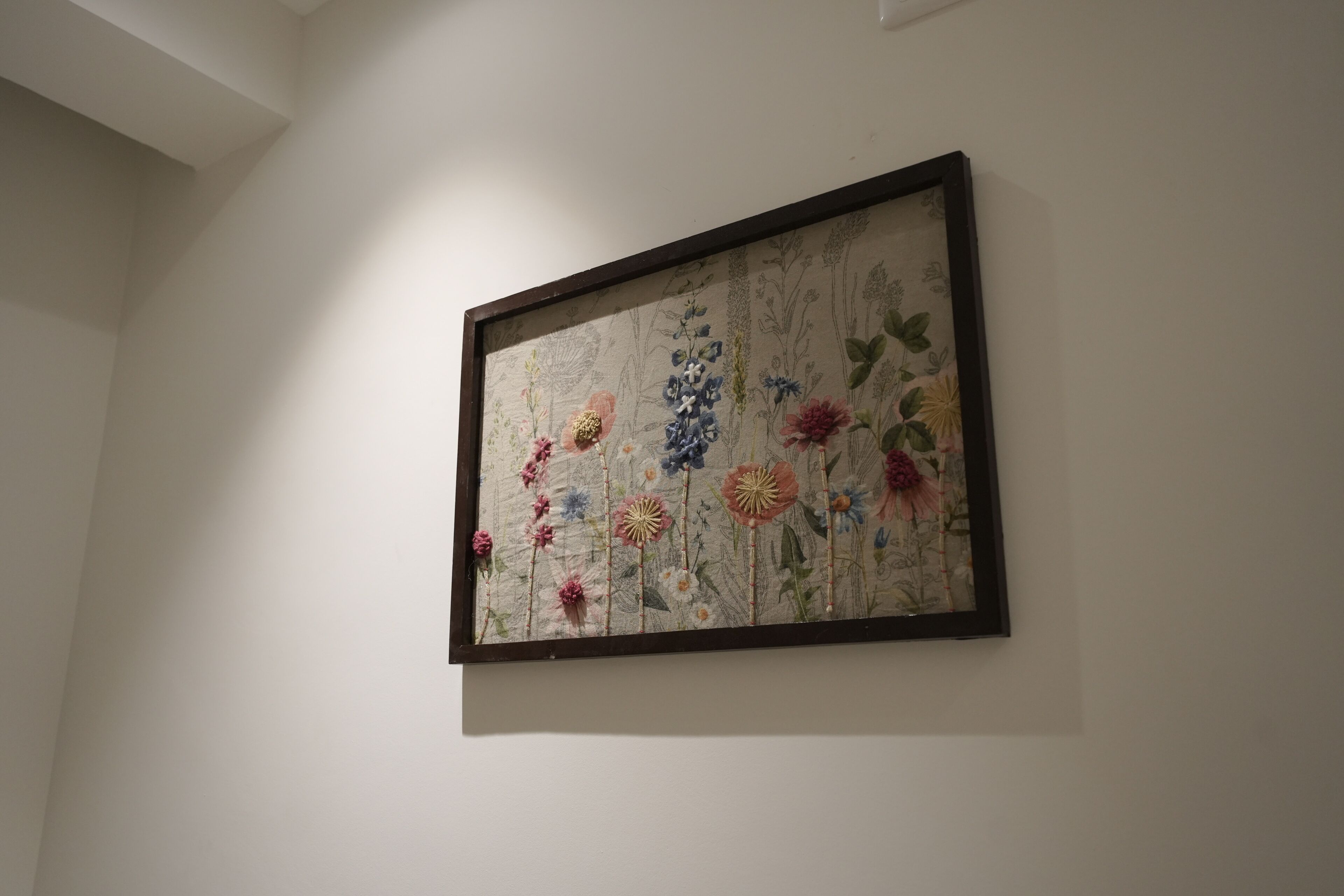 Uma obra de arte floral emoldurada em uma parede lisa.