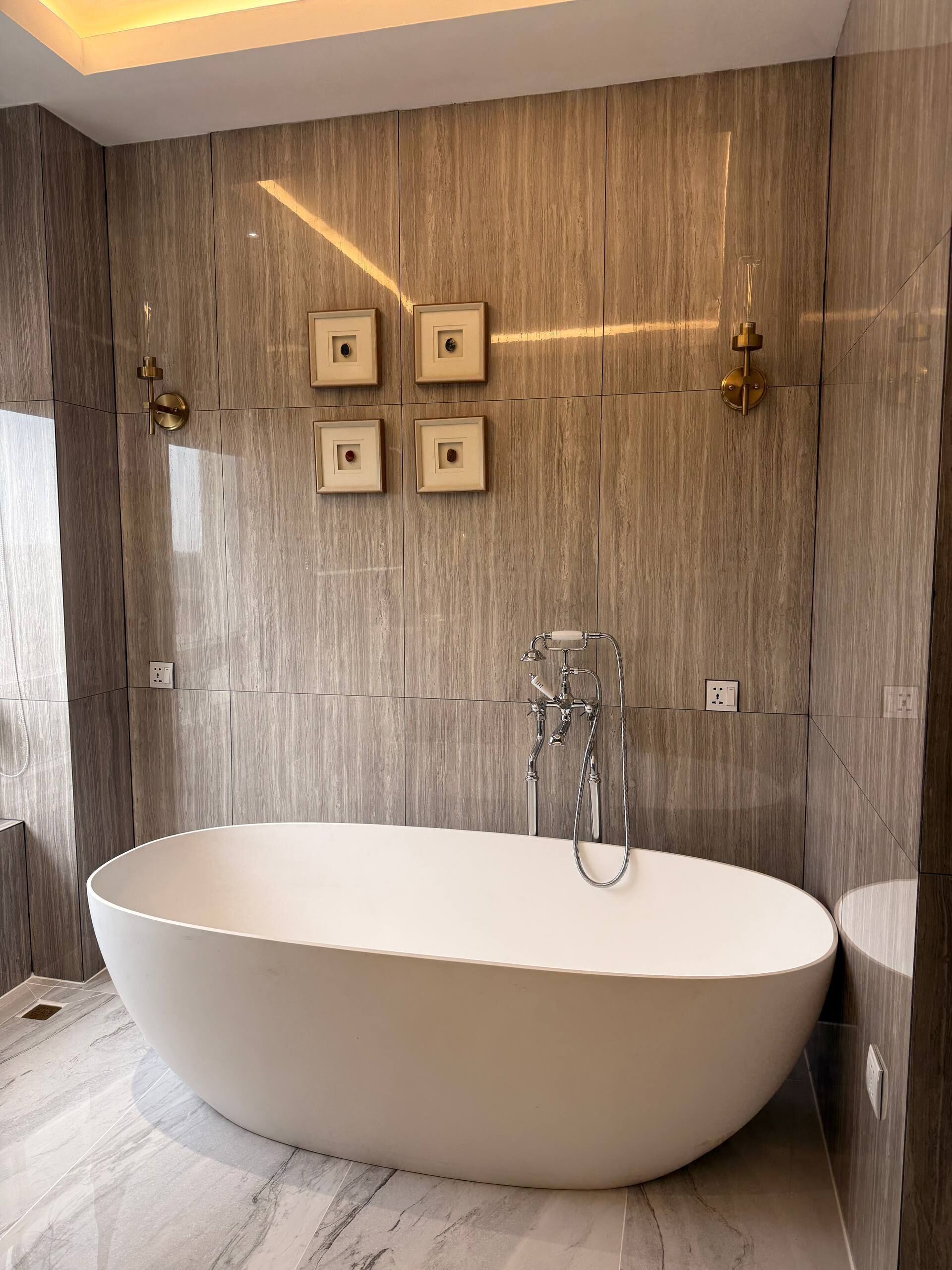 A modern bathroom with a freestanding bathtub, wall-mounted towel racks, and a large mirror.