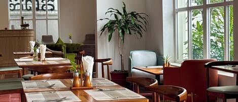 A restaurant with high arched ceilings, large windows, and wooden furniture.