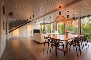 Une cuisine spacieuse avec un coin repas, de grandes fenêtres et un escalier.
