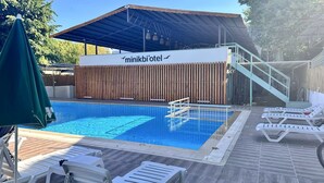 Une piscine avec des chaises longues et une clôture en bois.