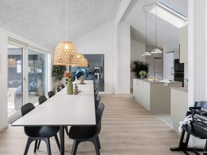 A modern kitchen with white cabinets, a central island, and a large window. - 5 Star Holiday Home in Idestrup (Idestrup)