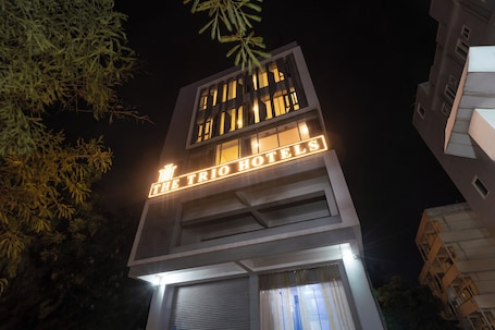 A building with illuminated signage reading 'The Trio Hotels.'. Treebo The Trio, Karmanghat