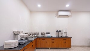 Una cocina con pileta de mármol, armarios de madera, encimera negra y un equipo de aire acondicionado.