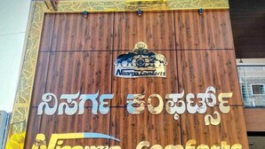 A wooden facade of a building with signage for 'Nisarga Comforts Lodge'. - Nisarga Comforts (Chikkamagaluru)