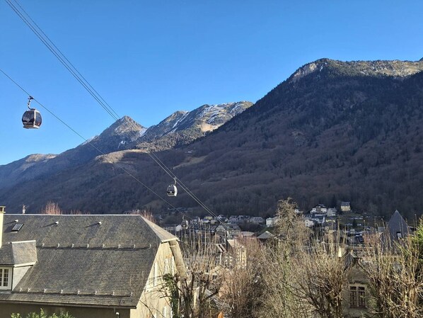Une ville de montagne dotée d'un télésiège, de bâtiments et surplombée d'un ciel bleu clair.