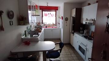 Cafetera o tetera, frigorífico, microondas y placa de cocina