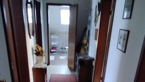 A hallway with a red carpet, a sofa, and a door leading to another room. - Beautiful 3 room trade fair apartment (Hannover)