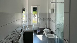 Un baño moderno con ducha, inodoro y lavamanos.