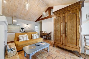 Un salon confortable avec un canapé, une table basse, un meuble en bois et une table à manger.