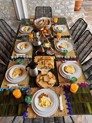 A breakfast table set with plates of eggs, toast, and pastries, accompanied by coffee and juice. - 10 minutes from sidi kaouki beach (Essaouira)
