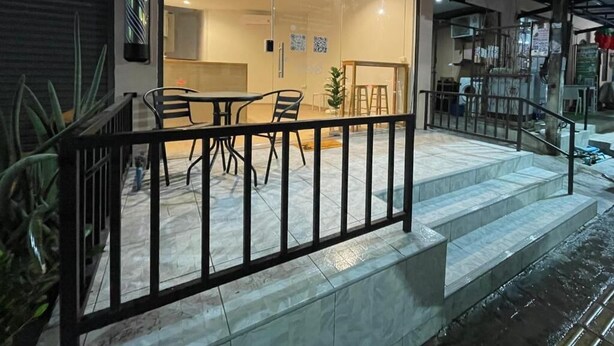 Ein Hotel mit Glasfassade, einer Treppe und einer Außenbereich-Sitzgelegenheit.