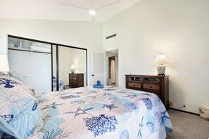 Ein Schlafzimmer mit einem Bett, einem Schminktisch, einem Spiegel und einem begehbaren Kleiderschrank.