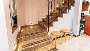 Un escalier avec des marches en marbre, une chaise en bois et une petite table.