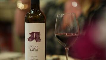 Una botella de vino con etiqueta y una copa de vino tinto.