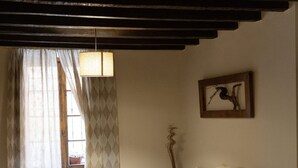 Un saló d'estar acollidor amb un sofà, una taula de centre de fusta i una làmpada penjant.