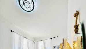 A modern bedroom with a large bed, a wooden headboard, a large mirror, and a window with white curtains. - Urban 10BR Retreat Near Rathausplatz (Vienna)