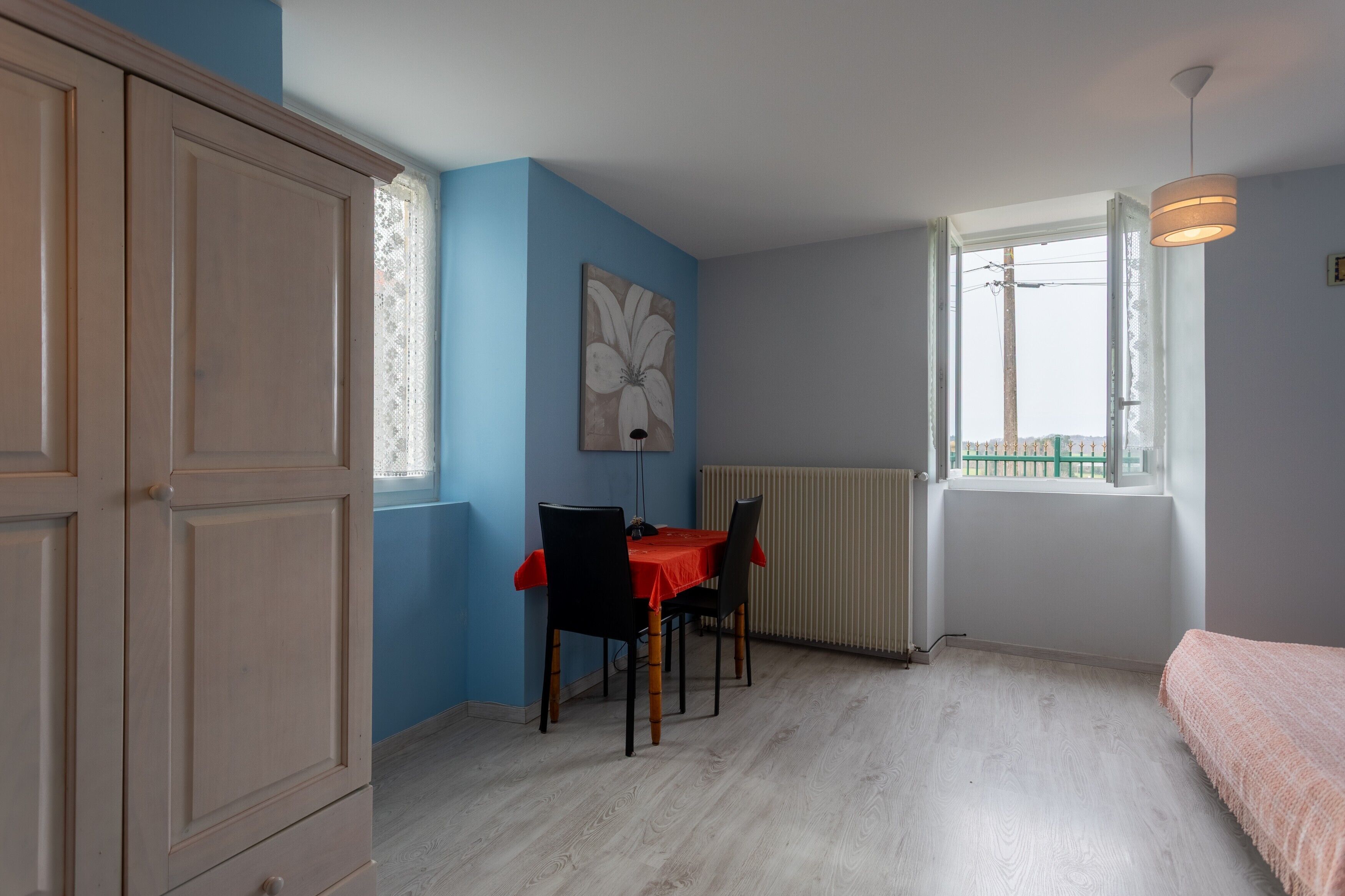 Ein Zimmer mit Esstisch, Stühlen, Heizkörper, Fenster und Blick.