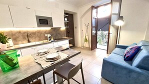 A modern kitchen with a dining area, a sofa, and a view of the outside. - Liberty apartment, Porta Susa center, wifii flat, parking, pets allowed (Torino)