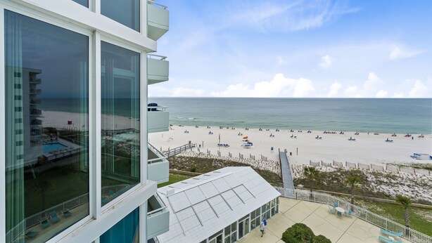 Hotel com vista para a praia, incluindo piscina e área de estar ao ar livre.