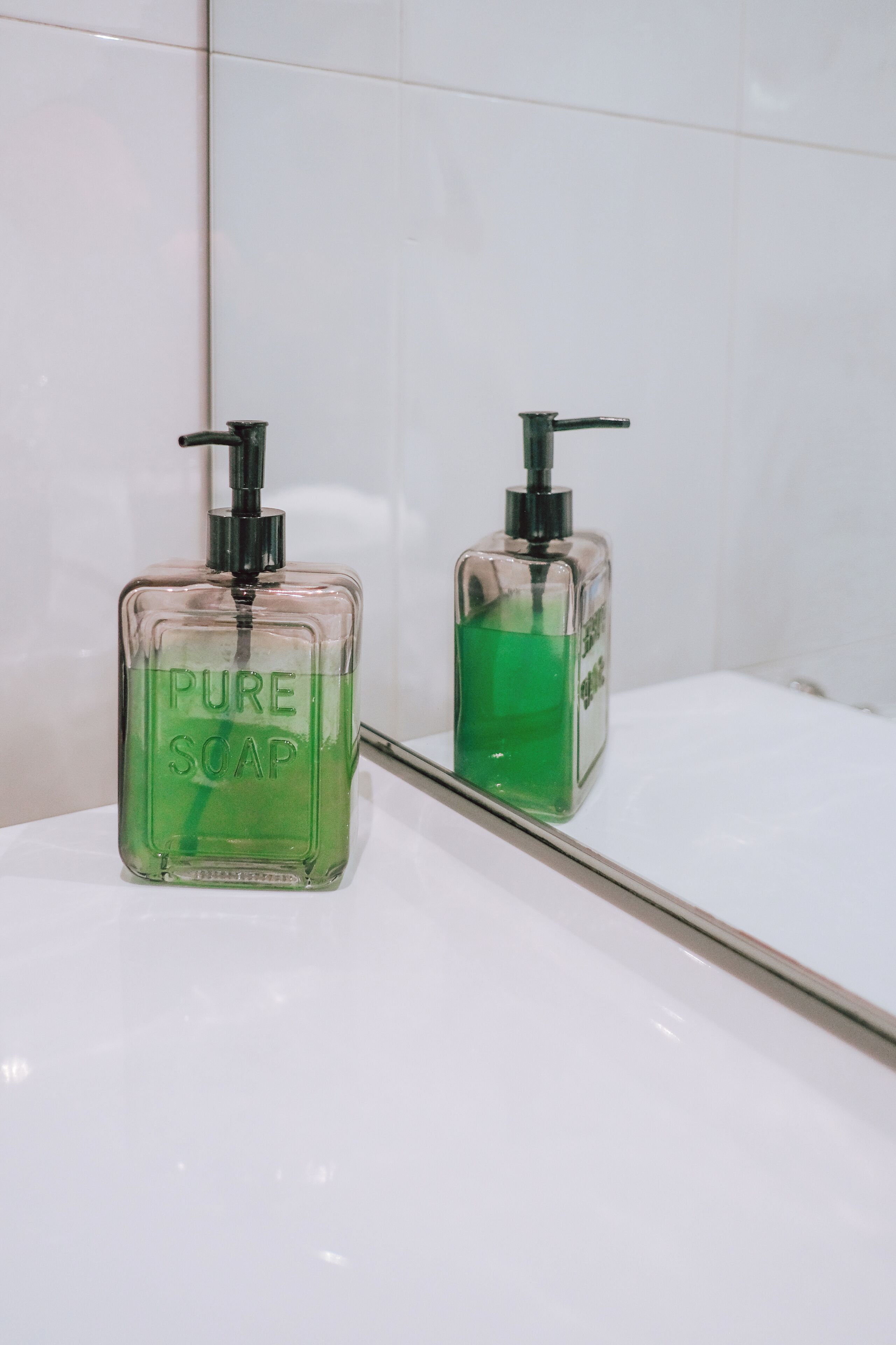 Two bottles of liquid soap on a white surface.