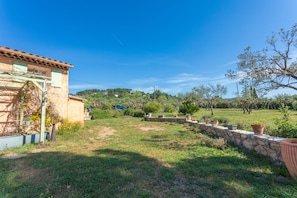 A rural property with a stone wall, potted plants, and a clear blue sky. - Holiday Home 'Bastidon Cotignac' with Shared Pool, Private Garden & Wi-Fi (Cotignac)