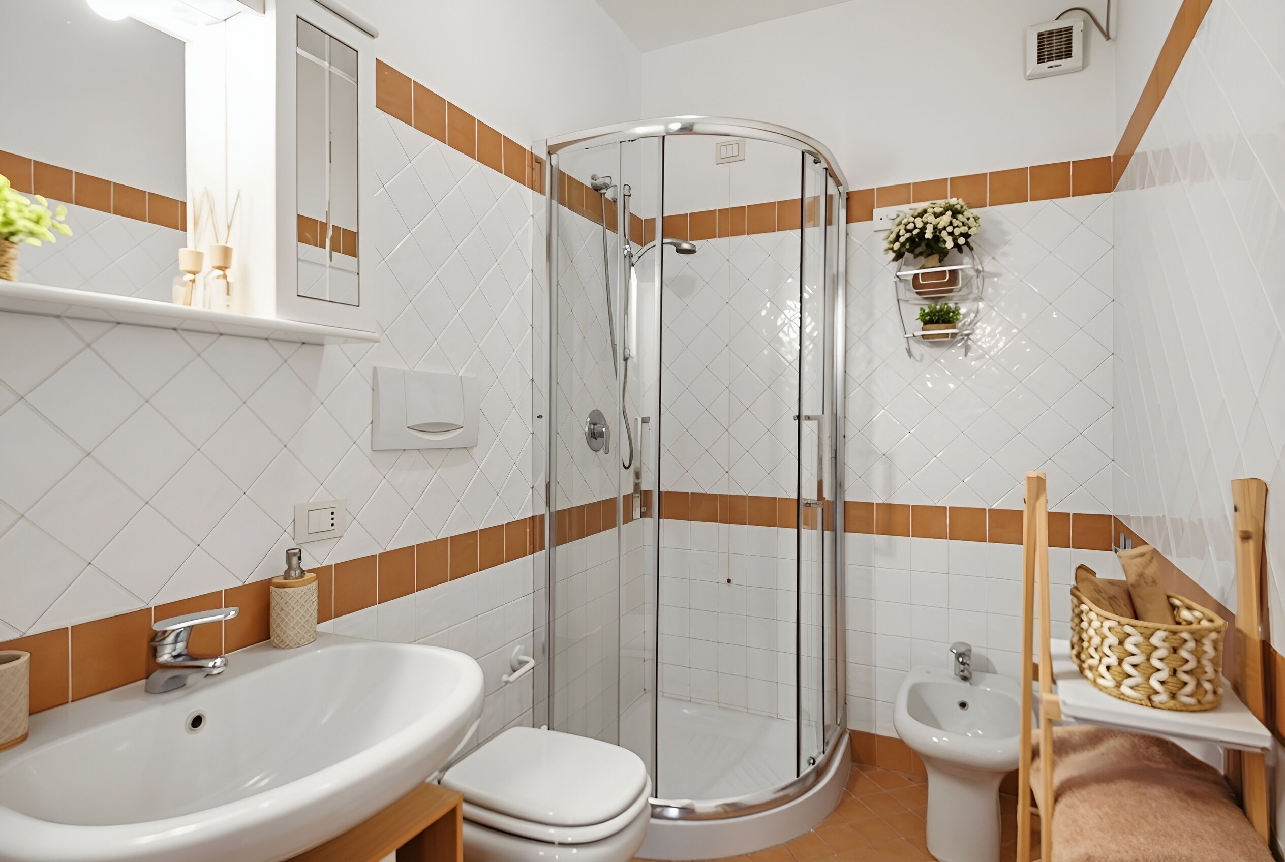 Un baño con ducha envuelta en vidrio, lavabo, inodoro y bidé.