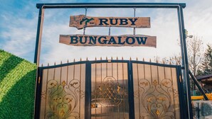 Una entrada protegida por un portón con un letrero que dice 'Ruby Bungalow'.