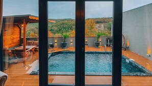 Un interior moderno con un amplio ventanal corredera que da a una zona de piscina al aire libre.