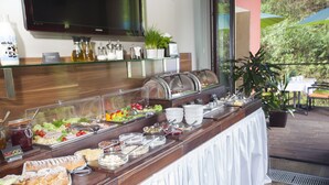 En buffet med forskelligt mad, et fjernsyn og en potteplante.