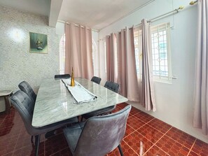 A dining area with a marble table, four chairs, a gold decorative item, and a painting on the wall. - Calm Nest 3-bedroom Apartment. 180m from the beach. Family and Business Trips! (Flic en Flac)