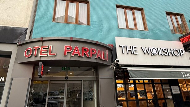 Un hotel llamado "OTEL PARPALI" con fachada moderna, múltiples ventanales y un letrero de "THE WOOSHOP" al lado.