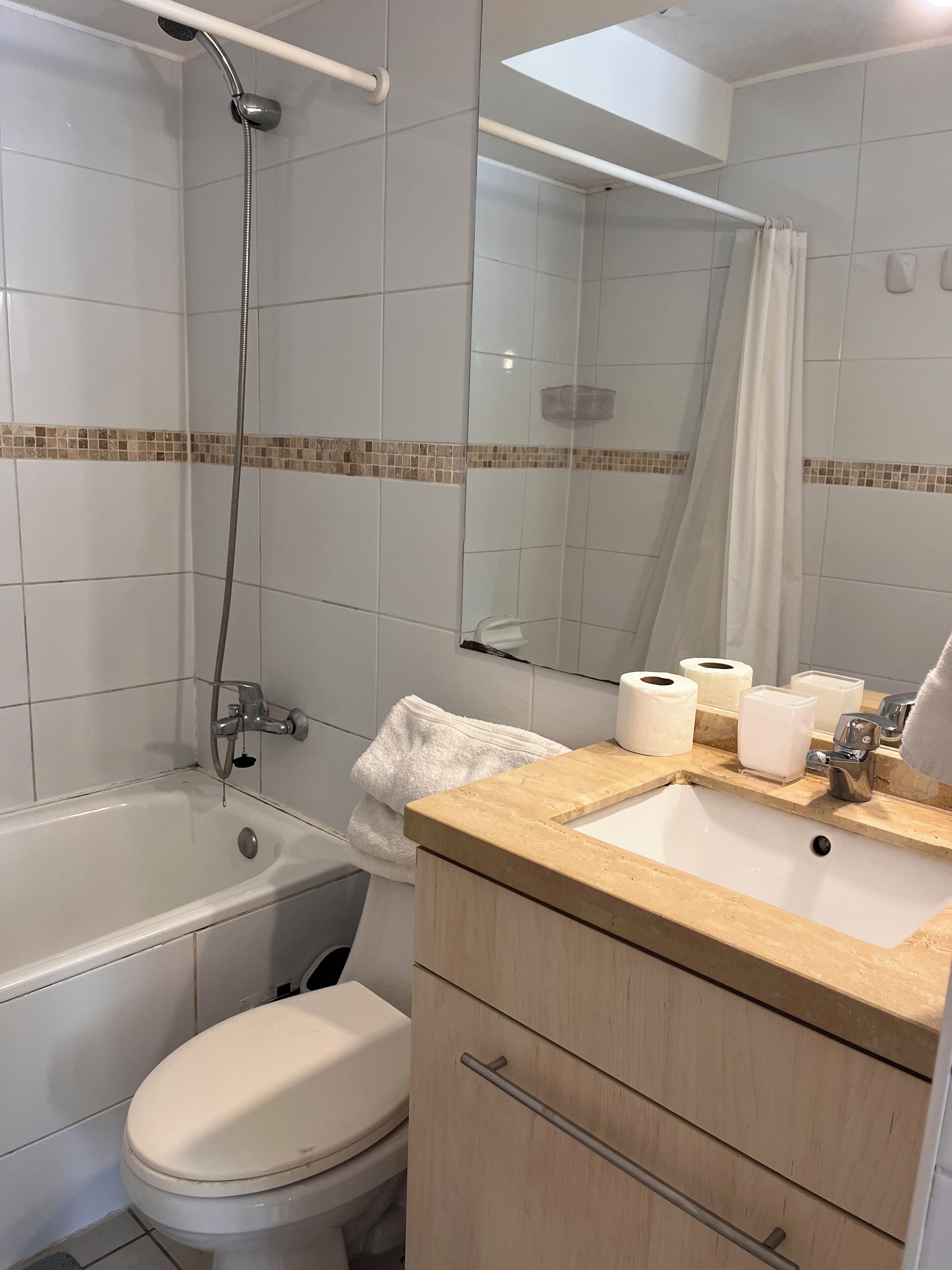 A bathroom with a bathtub, toilet, sink, and a mirror.